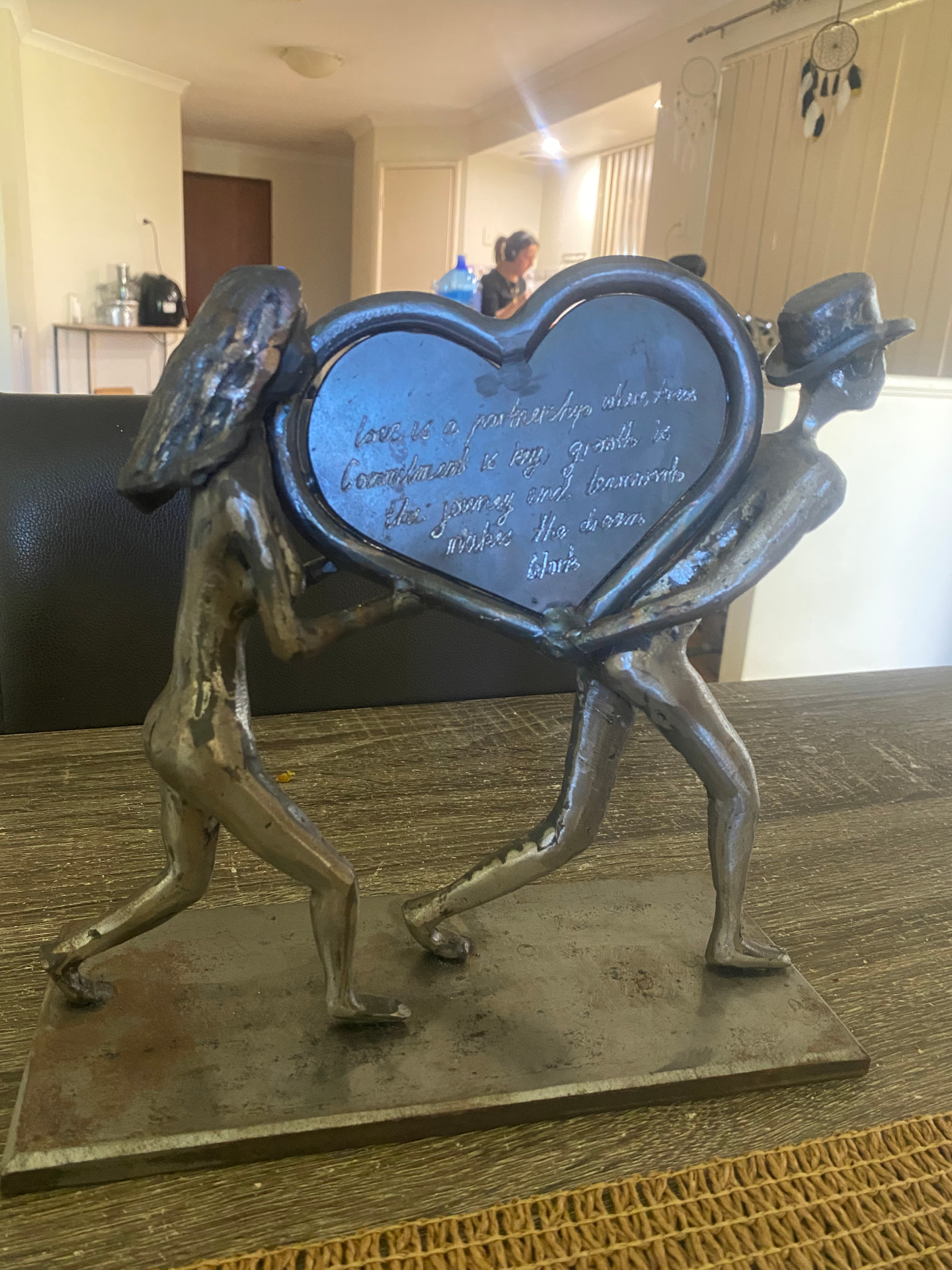 Hand fabricated steel sculpture of two figures carrying an engraved heart